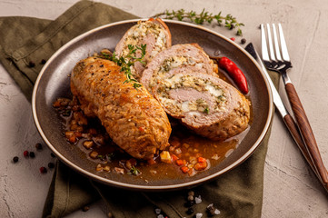 Baked meat rolls in a thick vegetable sauce. A large portion of sliced meat on a plate. Close up and horizontal view.