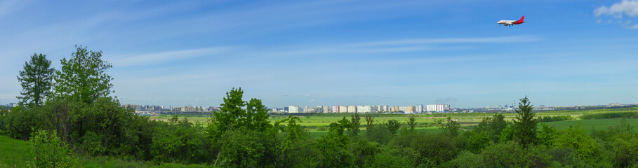 city panorama with the plane coming in the land in clear day