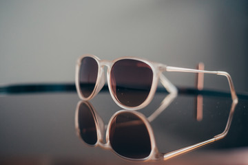 Fashion sunglasses on glass table with white background