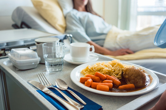 Essen wird einem Patienten im Krankenhaus ans Bett serviert