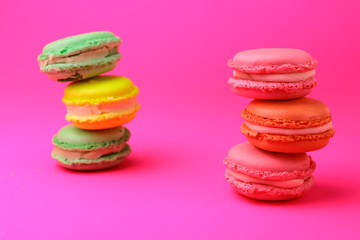 colorful macaroons stack on pink background.