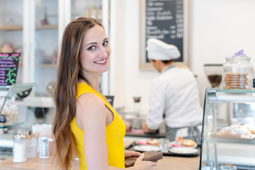 Woman in the pastry shop choosing sweet desserts