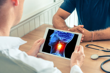 Doctor holding a digital tablet with x-ray of the 3D head of the patient with pain on the neck....
