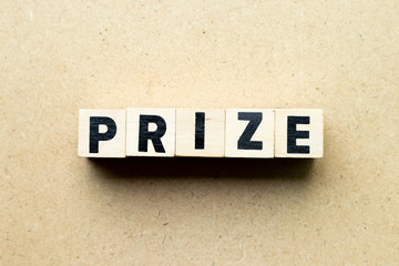 Letter block in word prize on wood background