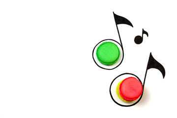 Sweet music creative background. Macaroon and hand drawn music notes on white background.  