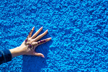 Arm with a traditional henna tattoo on the background of the blue wall. Rabat, Morocco