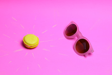 Sun creative concept. Sweet macaroon sun.  Yellow macaroon sun and sunglass on pink background.  Summer concept