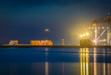 Fototapeta na wymiar Night view of the container terminal. Commercial port, City Odessa, Ukraine, June 2019. Night Lights.