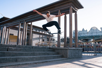 Skateboarder jumping from the steps. Skateboarding trick ollie. Young european guy on a skateboard....