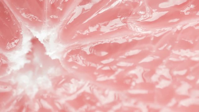Macro shot of pink colorful orange fruit/grapefruit slice. Fruit background. Camera locked down. Selective focus.