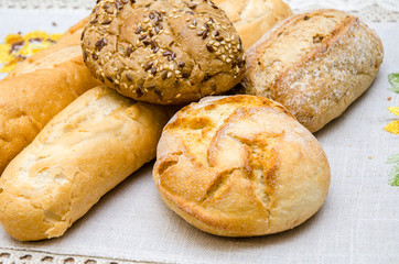 Freshly baked bread loaves on burlap dark wooden background. Texture closeup italian bakery products. Top view