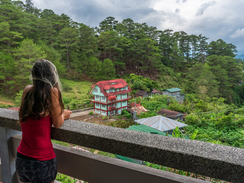 young girl looking to the horizon from the balcony