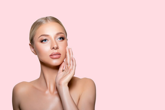 Beautiful young Woman with clean Fresh Skin. Beauty.  Closeup Model with perfect Healthy Skin touching your Face. Cosmetology. Studio shot. pink background. isolated. - Image 