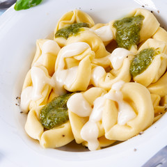 Tortellini di formaggio with basil pesto and cheese sauce