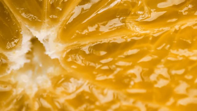 Macro shot of bright colorful orange fruit/grapefruit slice. Fruit background. Camera locked down. Selective focus.