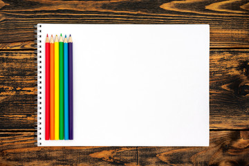 Colored pencils painted in LGBT colors and white card.