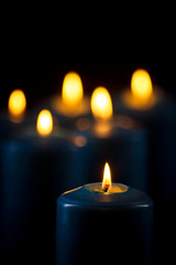 Lit blue candles on a black background
