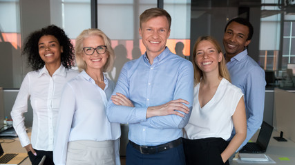 Successful team leader and diverse employees posing for photo together