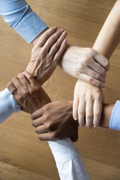 Close up multiracial business people holding each others wrists
