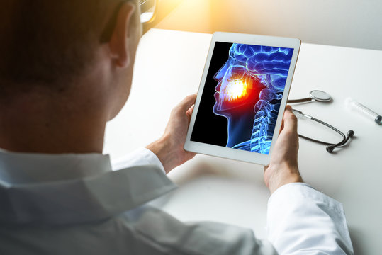 Doctor or dentist holding a digital tablet with x-ray 3D head skull and pain on the teeth