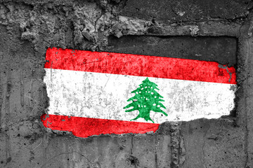 The flag of Lebanon on a dirty wooden surface, built into a concrete base, with scuffs and scratches. Loss or destruction conception.