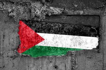 The flag of Palestine on a dirty wooden surface, built into a concrete base, with scuffs and scratches. Loss or destruction conception.