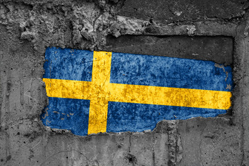 The flag of Sweden on a dirty wooden surface, built into a concrete base, with scuffs and...