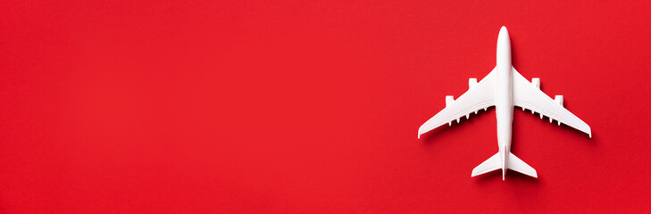 Travel, vacation concept. White model airplane on red color background with copy space. Top view....