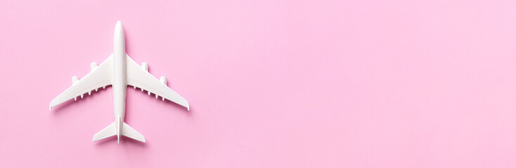 Creative layout. Top view of white model plane, airplane toy on pink pastel background. Flat lay...