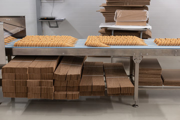 Obraz premium Ice cream production line. Conveyor production. Production of wafer cups for ice cream. Selective focus.