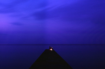 Fototapeta na wymiar 夜の海岸の釣りをしている人