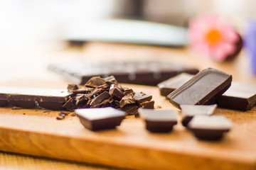 Cut chocolate pieces on the wooden background