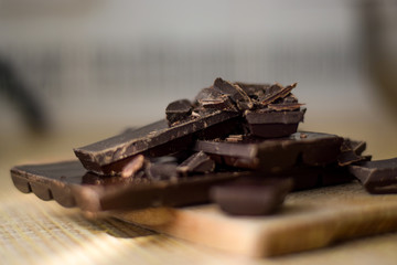 Cut chocolate pieces on the wooden background