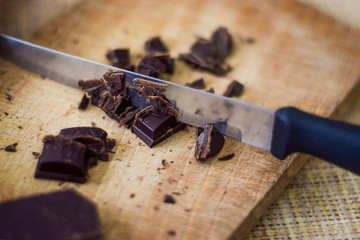 Cut chocolate pieces on the wooden background