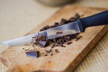 Cut chocolate pieces on the wooden background