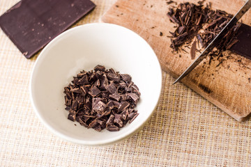 Cut chocolate pieces on the wooden background