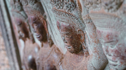 A row of ruined stone carving sculptures in on wall at one of the ancient temples of Angkor Thom. (Angkor Wat, UNESCO World Heritage, Siem Reap, Cambodia)