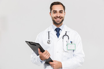 Portrait of european young medical doctor smiling at camera and holding health card