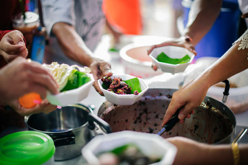 Volunteers give food to the poor : donating food is helping human friends in society : Helping People With Hunger With Kindness : the concept of life problems, hunger in society