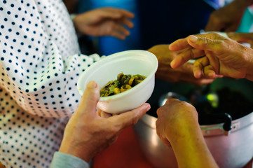 Concept of Feeding : Volunteers give food to the poor : donating food is helping human friends in society : Helping People With Hunger With Kindness : the concept of life problems, hunger in society