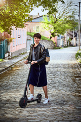 Girl riding a scooter in the countryside in summer.