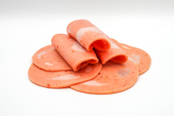 Bologna mixed with fresh chilli and pork ham, slides into a circular plate on a white background