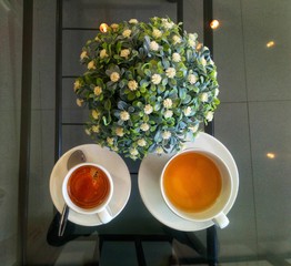 cup of coffee and flowers on wooden table
