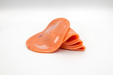 Bologna mixed with fresh chilli and pork ham, slides into a circular plate on a white background