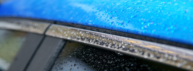 Blue metallic surface with water drops.