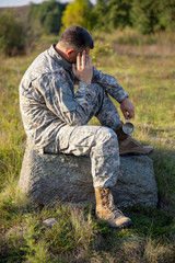 Fototapeta premium The soldier sits and rests. Sad and Tired soldier. Soldier