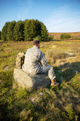 Soldier tying shoes. Soldier. Soldier in gear. The soldier sits and rests.