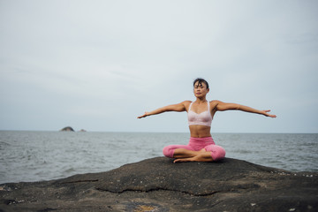 Asian girl practice Yoga on the beach Sunrise morning day