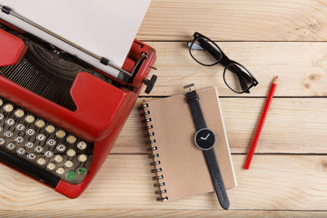 Writer or journalist workplace - vintage red typewriter on the wooden desk