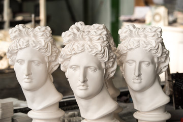 Obraz premium Gypsum sculptures. The heads of the gypsum apollo in the workshop.